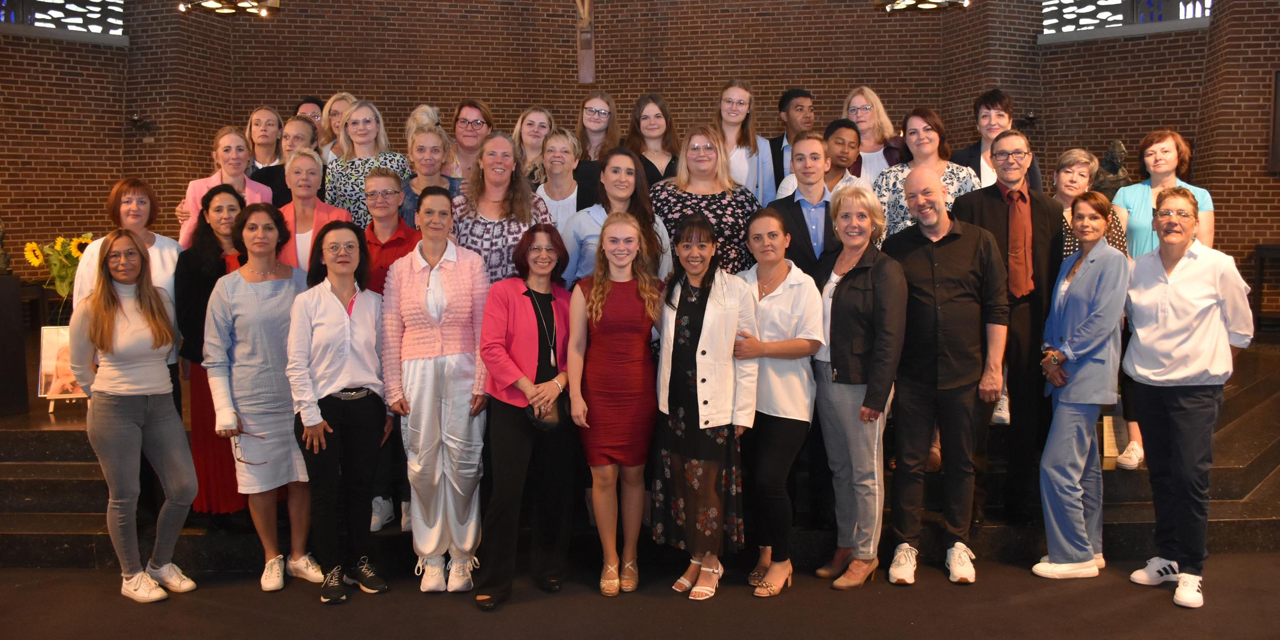 Gruppenbild mit Dozenten: die frisch examinierten Pflegefachmänner und -frauen sowie die Pflegefachassistentinnen und -assistenten.